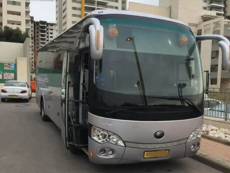 הסעות בפריסה ארצית - אוטובוס כסוף ומהודר באור יום, עם דלת נוסעים קדמית פתוחה.